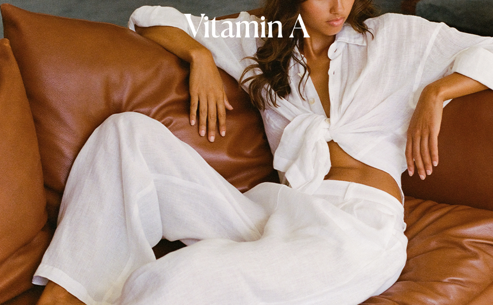 Woman lounging on sofa wearing white ecolinen with Vitamin A logo overlay